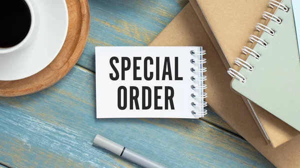 Text sign showing Special Order. A special item requested by the military headquarters for a daily note. White a blank sheet for notes on a wooden background.