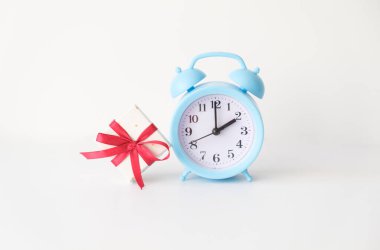 Beyaz arkaplanda hediye olan çalar saat.