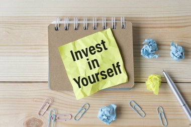 Finansal belgelerde bir hesap makinesinin görüntülenmesinde INVEST INSSELF Metni.