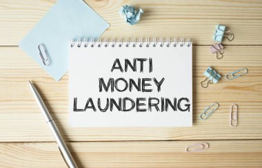Ofis masasına kırtasiye malzemesi ile ANTI PAREY LAUNDERING yazılı not. Kopya veya metin girmek için boş bir not defteri. iş