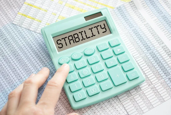 STABILITY TEXT ON DISPLAY CALCULATOR A GRAY BACKGROUND. BUSINESS CONCEPT