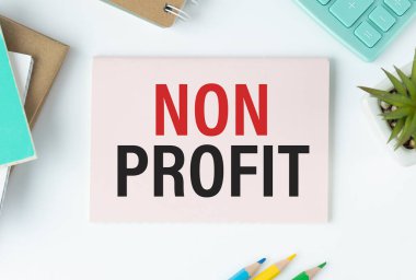 Kalem ve hesap makinesinin yanındaki masaüstündeki bir dizüstü bilgisayarda NON PROFIT metni