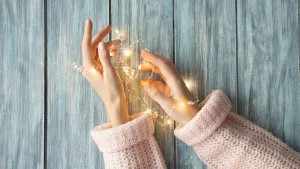 Christmas Card Beautiful Sparkle Xmas Lights Nest Hands Wooden Background — Foto de Stock
