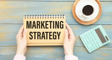 Pazarlama stratejisi planlıyorum. Üst görüntüde, ahşap masada otururken renkli çizimlerle el ele tutuşan bir adam görülüyor.