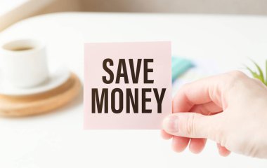 Elindeki tablodaki beyaz karta para tasarrufu metni yaz.