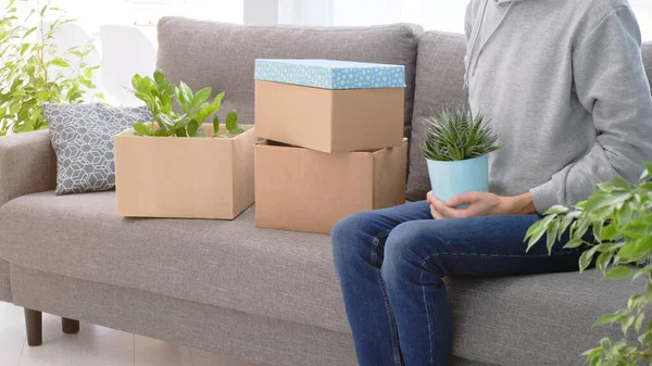 Close up of man carrying removal box as couple move in or out of new home together