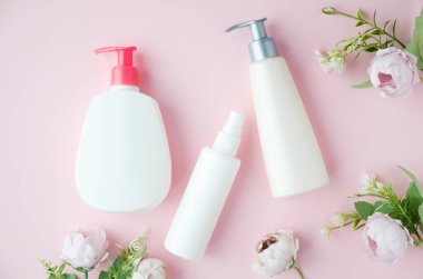 krem tüpler, kozmetik dispenser, boş kavanoz ve el kremi ile üst görünümü, pembe maskara şişeleri