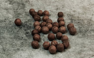 Tahta bir masada organik Macadamia fındıkları.