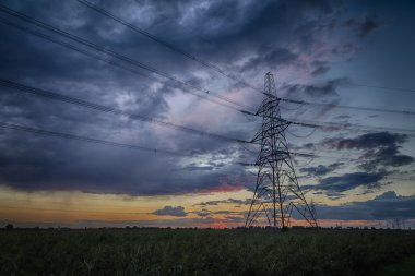Alacakaranlık ve ufukta fırtına elektrik pilon