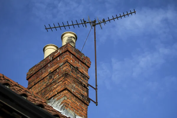 Camino su un tetto con antenna TV e cielo blu con nuvola di luce — Foto Stock