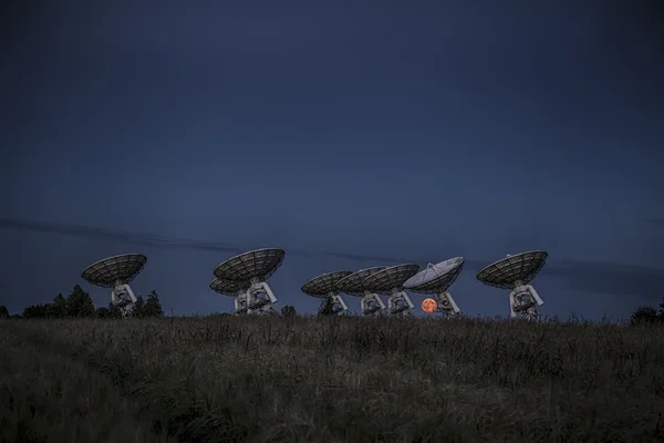 Volle maan stijgt boven schotelantenne — Stockfoto