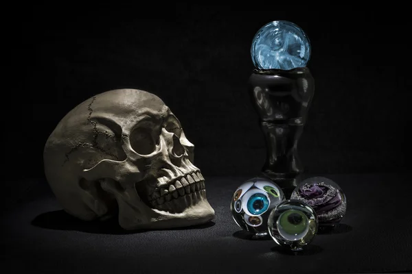 Calavera y bolas de cristal mágico con ojos espeluznantes mirando — Foto de Stock