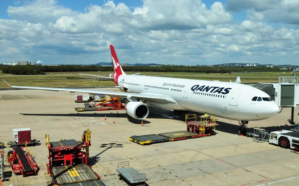 Brisbane, Avustralya - 7 Eylül 2015: Qantas işletilen Airbus A330-303 Brisbane Uluslararası Havaalanı'nda yükleniyor