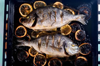 Limon dilimleriyle doldurulmuş Dorado balığı ve pişirmek için yeşil biberiye.