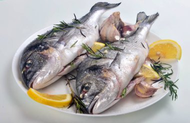 Limon dilimleriyle doldurulmuş Dorado balığı ve pişirmek için yeşil biberiye.