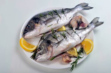 Limon dilimleriyle doldurulmuş Dorado balığı ve pişirmek için yeşil biberiye.