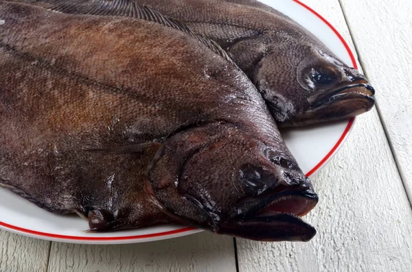 Δύο Ολόκληρα Φρέσκα Ψάρια Λευκό Πιάτο Και Λευκό Ξύλινο Φόντο — Φωτογραφία Αρχείου