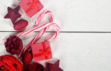 Hediye kutuları ve kırmızı Noel süslemeleri olan bir Noel köşesi. Beyaz ahşap tahta arka plan. Boşluğu kopyala.