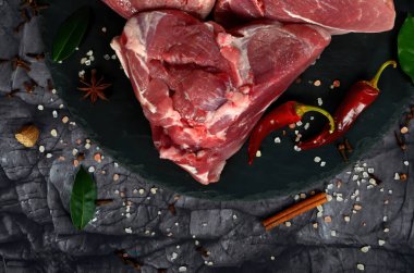 Siyah taş arka planda baharatlı taze çiğ koyun eti. Büyük parça shmeat fileto ya da fileto yakın çekim