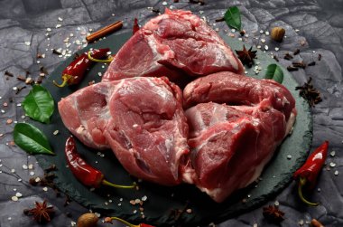 Siyah taş arka planda baharatlı taze çiğ koyun eti. Büyük parça shmeat fileto ya da fileto yakın çekim