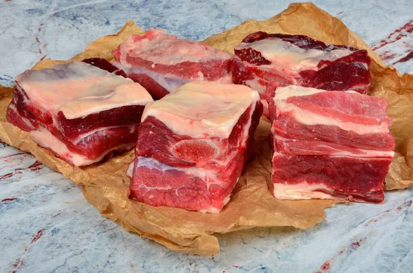 牛肉排骨在褐色的食物纸上 背景为浅色的天然石材 生鲜有机牛肉短边 — 图库照片