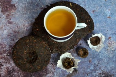 Çeşitli Çinlilerin puer çay kreplerinin olduğu bir fincan çay. Yüksek kalitede Çin porseleni çayı..