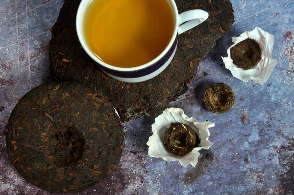 Çeşitli Çinlilerin puer çay kreplerinin olduğu bir fincan çay. Yüksek kalitede Çin porseleni çayı..