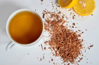 Bir fincan çay, beyaz arka planda Catuaba kabuğu ve limon. Catuaba ağaç kabuğundan doğal bitki çayı, Brasilia 'dan doğal afrodizyak.