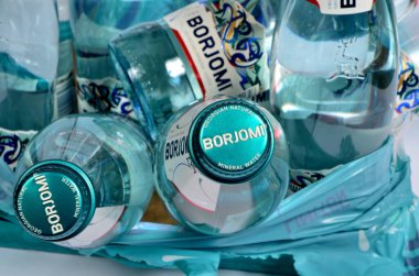 Riga, Letonya 24 Kasım 2020: Kırık şişe Borjomi mineral köpüklü su beyaz zemin üzerinde