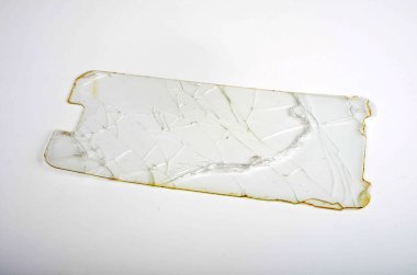 Beyaz arka planda cep telefonunun kırık koruyucu camı.