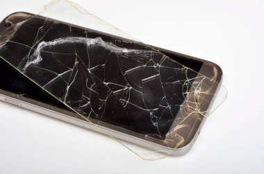 Telefonun arka planında kırık bir koruyucu cam var.