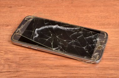 Telefonun arka planında kırık bir koruyucu cam var.