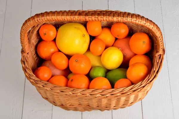 Vários Citrinos Uma Cesta Vime Uma Tábua Branca — Fotografia de Stock