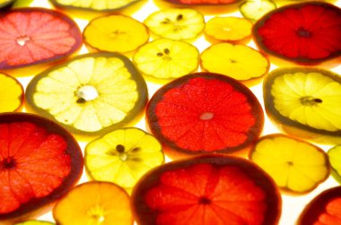 Dilimlenmiş narenciye arkaplanı bir ışık masasında. Şeffaf narenciye dilimleri. Kırmızı greyfurt, portakal, limon, limon, mandalina