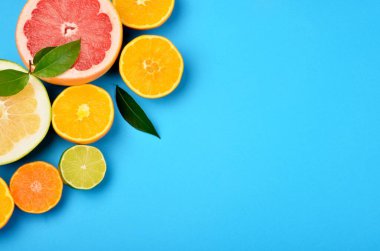 Kesilmiş turunçgilleri mavi arka planda, turunçgillerin arka planında, kopyalama alanlarında yerleştirilmiş ve dilimlenmiş.