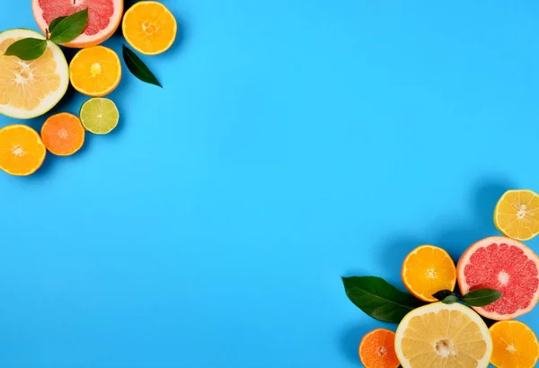 Kesilmiş turunçgilleri mavi arka planda, turunçgillerin arka planında, kopyalama alanlarında yerleştirilmiş ve dilimlenmiş.