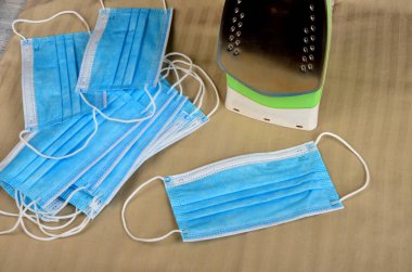 Elektrikli ütü ve mavi yüz maskeleri. Korunma ve önleme kovid19, Coronavirus konsepti.