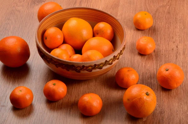 土鉢や木の背景に新鮮なみかんとオレンジ — ストック写真