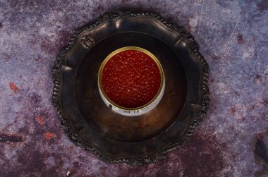 Antika gümüş tabakta kırmızı somon havyarlı teneke kutu. Rustik arkaplan, üst görünüm, kopyalama alanı