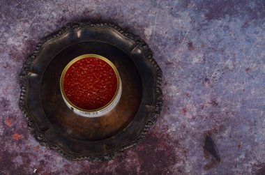 Antika gümüş tabakta kırmızı somon havyarlı teneke kutu. Rustik arkaplan, üst görünüm, kopyalama alanı