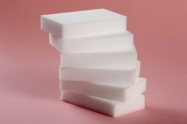 Melamine ev süngeri. Pembe arka planda melamin süngerler, mutfak ve ev temizliği araçları