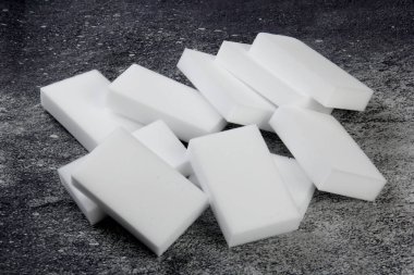 Melamine ev süngeri. Koyu arkaplanda melamin süngerler, mutfak ve ev temizliği araçları