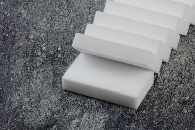 Melamine ev süngeri. Koyu arkaplanda melamin süngerler, mutfak ve ev temizliği araçları