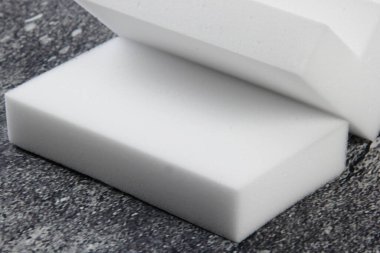 Melamine ev süngeri. Koyu arkaplanda melamin süngerler, mutfak ve ev temizliği araçları