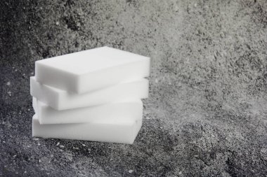 Melamine ev süngeri. Koyu arkaplanda melamin süngerler, mutfak ve ev temizliği araçları