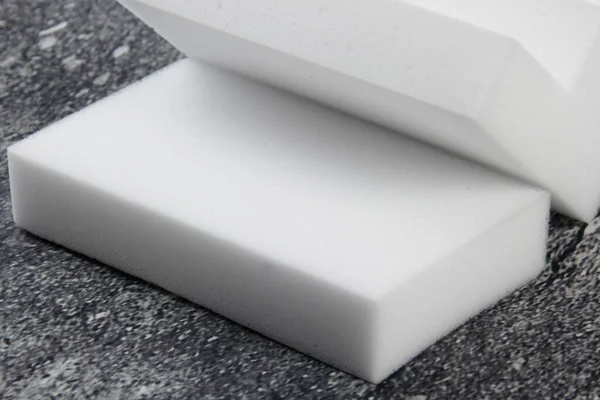 Melamine ev süngeri. Koyu arkaplanda melamin süngerler, mutfak ve ev temizliği araçları