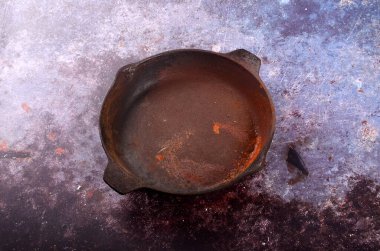 Paslı metal, rustik bir arka planda. Dökme demir tavanın yenilenmesi. Eski, paslı, dökme demir tava. Yukarıdan görünüm