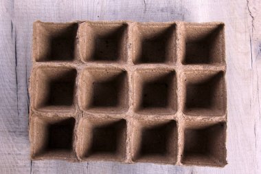 Gri ahşap arka planda boş turba kapları. Fidanlar için turba kapları