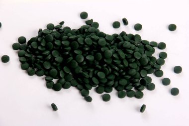 Beyaz arkaplanlı, yeşil haplar. Sağlıklı süper gıda diyeti ve detoks beslenme konsepti 