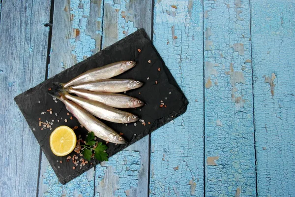 Fresh Smelt Fish Black Stone Plate Wooden Background Old Blue — Stock Photo, Image